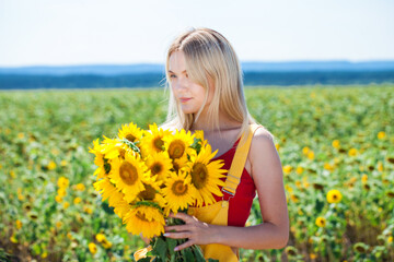 Young beautiful girl with a bouquet of sunflowers