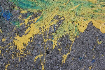 Splashes of yellow and blue paint on the sidewalk.