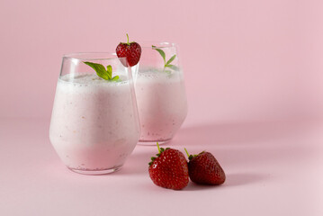 Homemade strawberry milkshake on pink background.  Consept of healthy food and home coocking. Copy space.