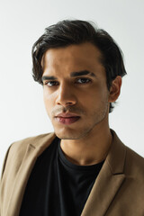 Obraz premium portrait of young man in stylish blazer looking at camera isolated on grey