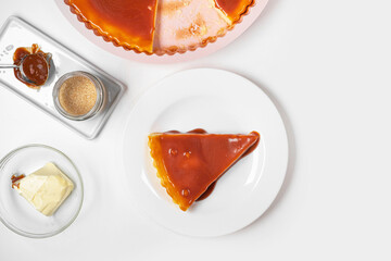 Homemade cheesecake slice with caramel on white background. Copy space for text.