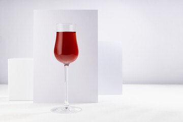 Red porto wine in luxury high glass in hard light with shadow in soft light white abstract interior with geometric surfaces in minimal style. - obrazy, fototapety, plakaty