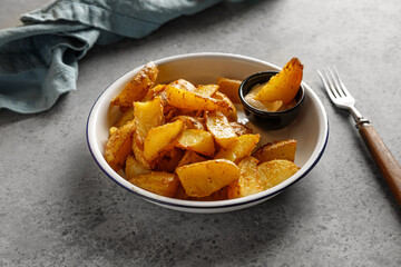 Baked potatoes on plate on grey table with napkin