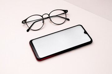 cell phone and glasses on a white background