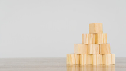 Empty wooden blocks on pyramid-like table, business growth concept on white background.