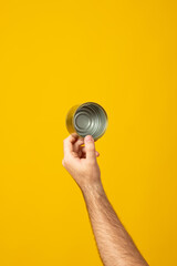Fototapeta na wymiar Hands hold recycling used cans, metal objects isolated on yellow background. Stop nature garbage, ecology environment protection concept. Save planet packaging mockup.