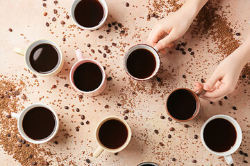 Female hands and cups of coffee on color background