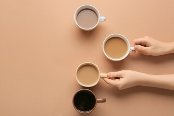 Female hands and cups of coffee on color background