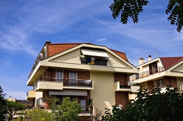 Fototapeta na wymiar Italian residential building with prismatic roof finished with tiles and balconies (Marche, Italy, Europe)