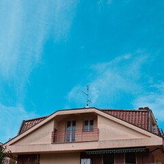 Italian residential building with prismatic roof finished with tiles and balconies (Marche, Italy, Europe)
