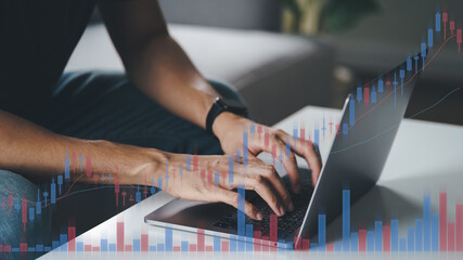 Man stock trading at home using computer, Hands typing on laptop keyboard, Double exposure with stock trading graph, Cryptocurrency, Stock market analysis concept..