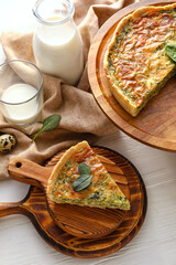 Tasty spinach tart and milk on light wooden background
