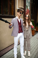 Young fashion man and stylish young woman in a formal suit outdoor in the city