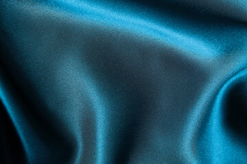 Blue silk drapery and upholstery fabric from the courtyard. Blue satin, silky fabric, wave, draperies. Beautiful textile backdrop. Close-up. Top view