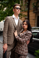 Young fashion man and stylish young woman in a formal suit outdoor in the city
