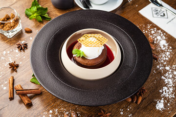 Chocolate fondant. Dark chocolate, raspberry sauce, vanilla ice cream dessert. Delicious healthy traditional food closeup served for lunch in modern gourmet cuisine restaurant