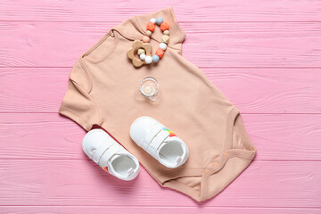 Obraz na płótnie Canvas Baby clothes, shoes and accessories on color wooden background