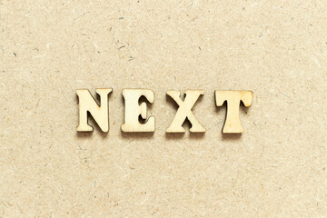 Alphabet letter in word next on wood background