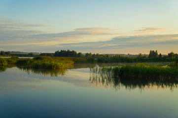 Fototapeta na wymiar Beautiful calm golden landscape at the sunset of the lake