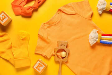 Baby clothes, toys and headband on color background, closeup