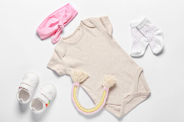 Baby clothes, toy, shoes and headband on white background