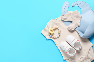 Baby clothes, shoes and accessories on color background