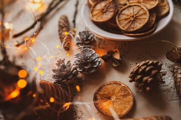 Christmas New Year top view of handmade crafts with pine cones, dry round slices of oranges, garland, branches. New year holiday, celebration concept. Flatlay