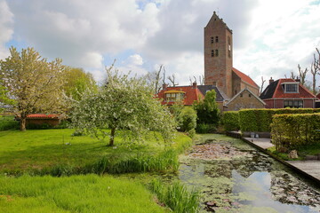 Fototapeta na wymiar The Roman church and traditional houses in Bozum, Friesland, Netherlands, a small village located 20km South from Leeuwarden