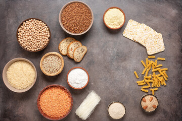 Fototapeta na wymiar Selection of gluten free food on a brown rustic background. A variety of grains, flours, pasta, and bread gluten-free. Top view, flat lay.
