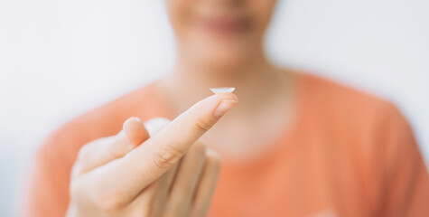 Young girl holding lens for vision on her finger