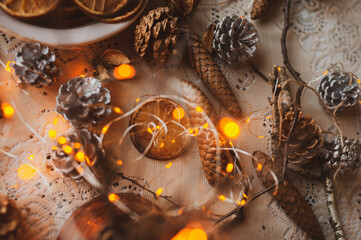Christmas New Year top view of handmade crafts with pine cones, dry round slices of oranges, garland, branches. New year holiday, celebration concept. Flatlay