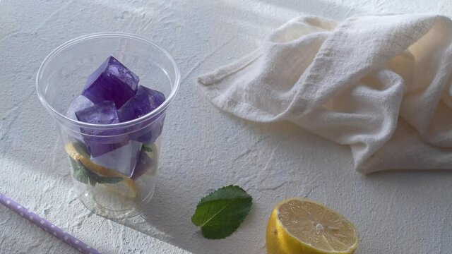 Refreshing summer drink, iced organic blue and violet butterfly pea flower tea with mint and lemons