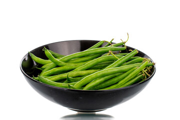 Several ripe green beans in a black ceramic plate, close-up, isolated on white.