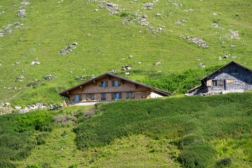 Fototapeta na wymiar Alp cabins at mountain Brienzer Rothorn on a sunny summer morning. Photo taken July 21st, 2021, Flühli, Switzerland.