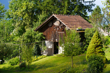 Fototapeta na wymiar Wooden cabin with wooden agricultural tools on a beautiful sunny summer morning. Photo taken July 21st, 2021, Flühli, Switzerland.