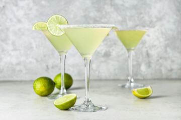 Glasses with tasty daiquiri cocktail on light background