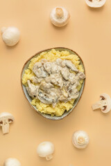 Bowl with tasty mashed potatoes and mushrooms on color background