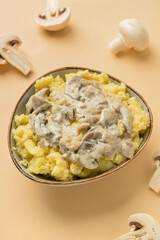 Bowl with tasty mashed potatoes and mushrooms on color background