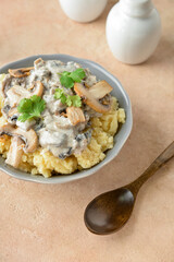 Bowl with tasty mashed potatoes and mushrooms on color background