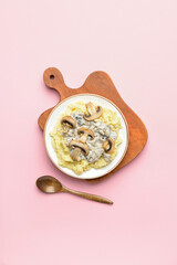 Plate with tasty mashed potatoes and mushrooms on color background