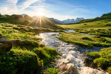 alpine creek at sunrise with peak of Titlis near Melchseefrutt in the swiss alps