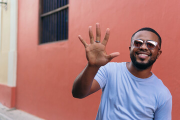 Smiling African man showing his hand while walking in the open air