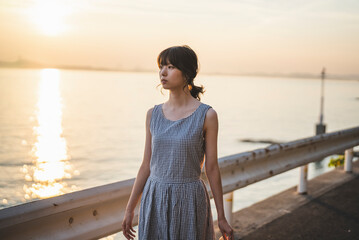 Fototapeta premium 夕暮れの海にいる女性