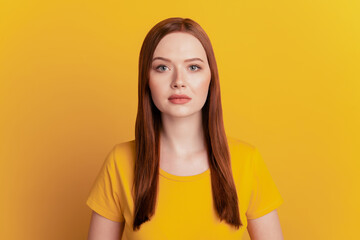 Young beautiful girl isolated on yellow background with serious expression
