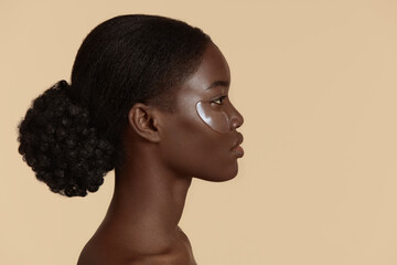Close up of beautiful african girl with under eye patch on face. Profile of serious young woman...