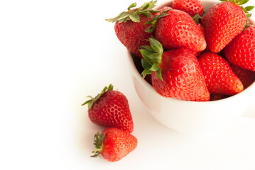 Red strawberries in a white cup isolated on white background