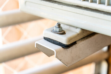 Bolt, nut and brackets for fixing the hanging outdoor unit of an air conditioner.