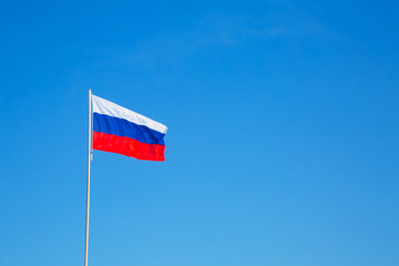 russian flag on a pole against blue sky. copy space