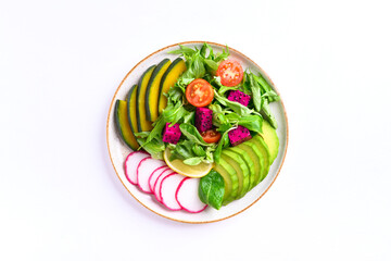 Healthy vegan salad fruits and vegetables with avocado, dragon fruit, radish, pumpkin, tomato, corn salad, lettuce, mizuna and lemon on white background