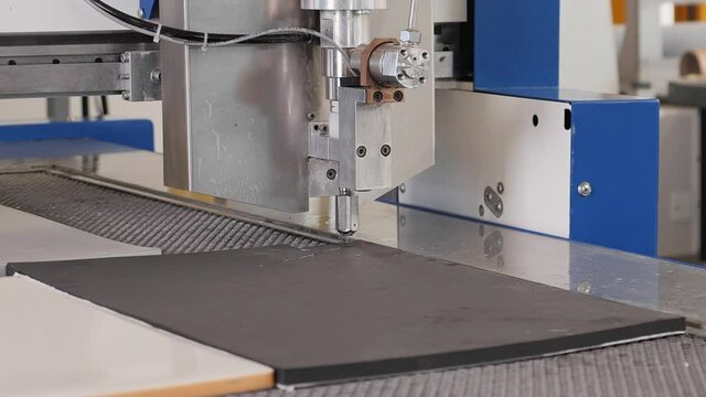 Industrial, manufacturing, technology concept. Cnc automatic waterjet cutting machine working with plastic foam using high-pressure water jet  - close up